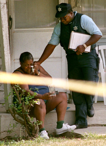 Fort Wayne Police Detective Kevin Senter, right, comforts a woman whose husband was shot and killed at their home.