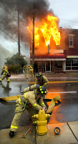 Fort Wayne firefighters work to hook a hose to a fire hydrant while fighting  a fire at Henry's Restaurant.