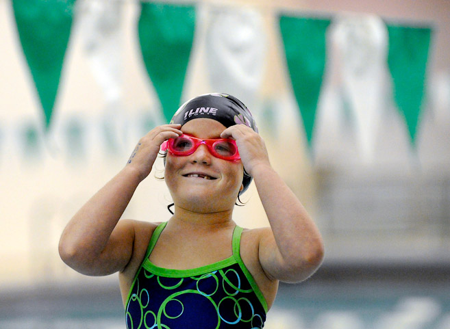 Six-year-old Kayleigh Cummings of Columbia City smiles to her mom in the stands as she prepares to swim in the City Swim Meet preliminaries for ages 8 & Under at the Helen Brown Natatorium.