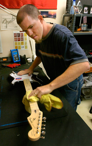 Marty Faley, a guitar technician at Sweetwater Sound, inspects a brand-new Fender Stratocaster Eric Clapton model guitar before it is shipped out to a customer.